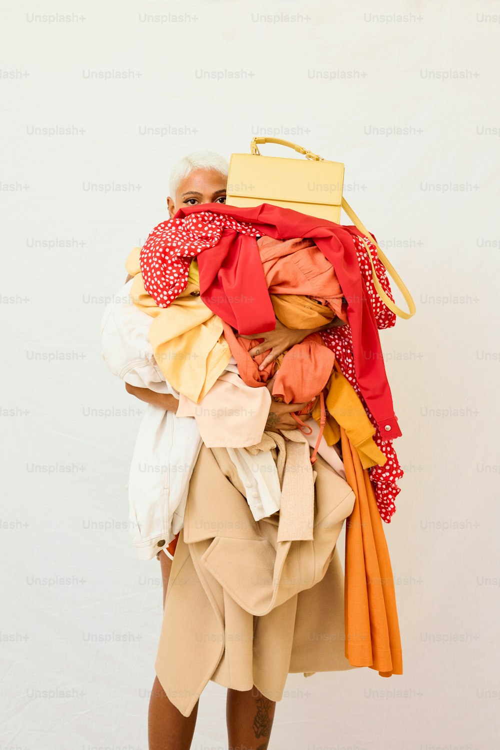 uma mulher carregando uma grande pilha de roupas nas costas