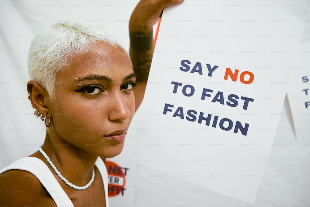 a woman with white hair holding up a sign