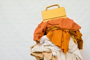 a yellow suitcase sitting on top of a pile of clothes