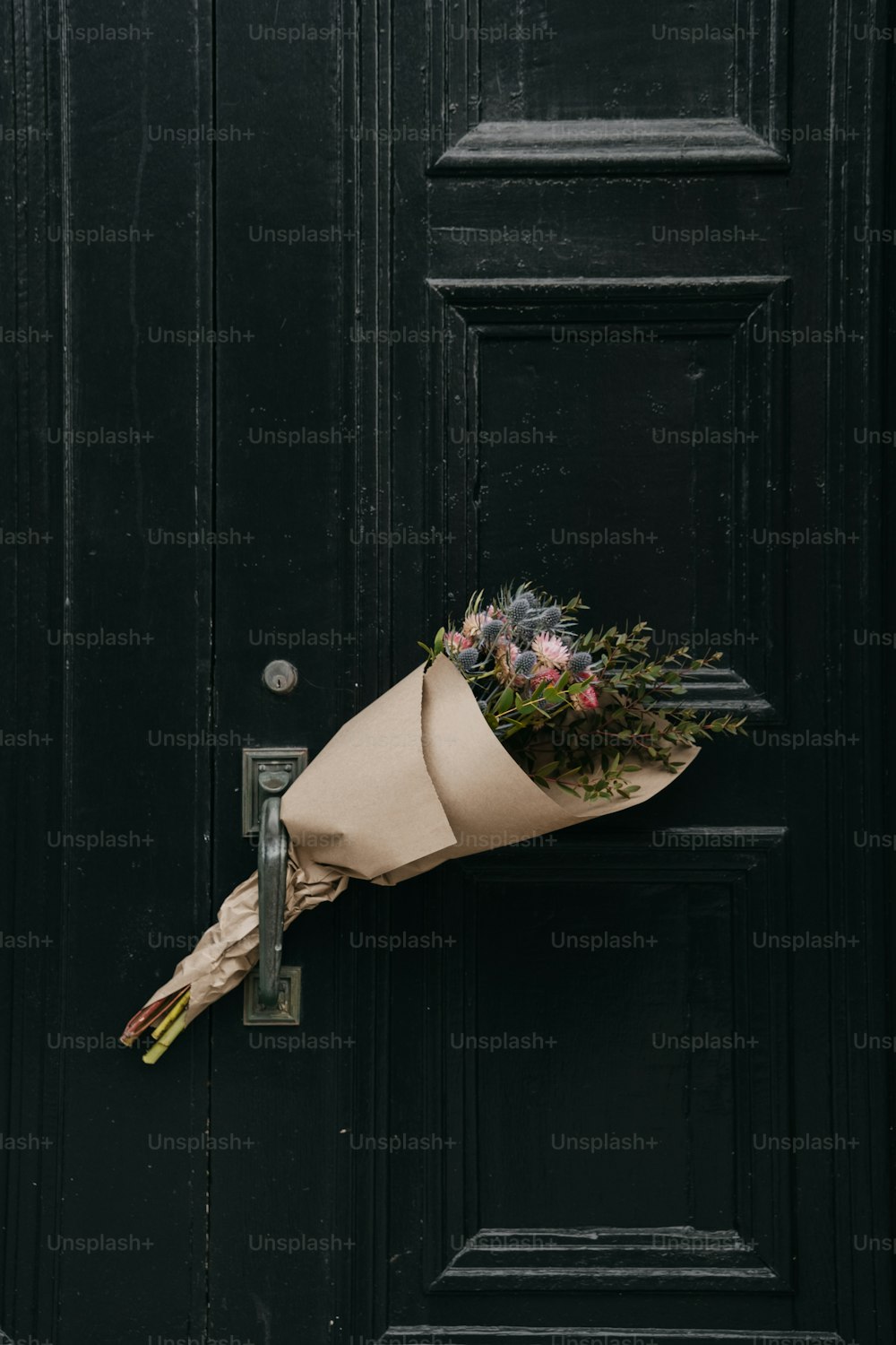 un ramo de flores sentado en la manija de una puerta