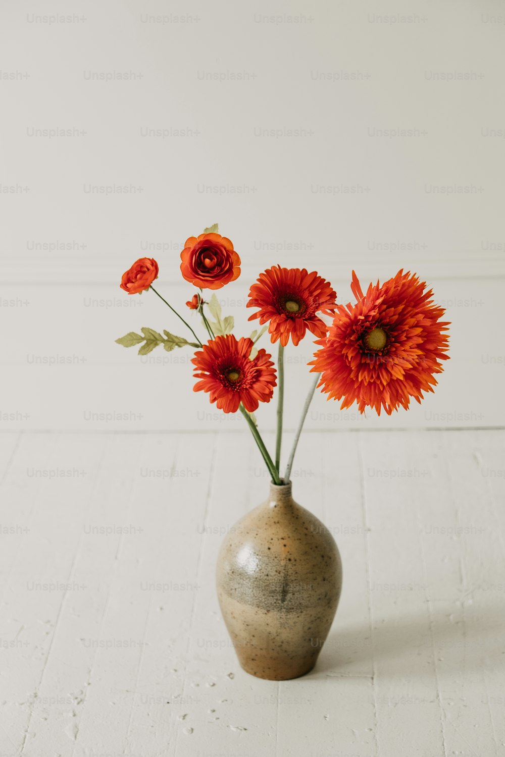 a vase filled with red flowers on top of a white table