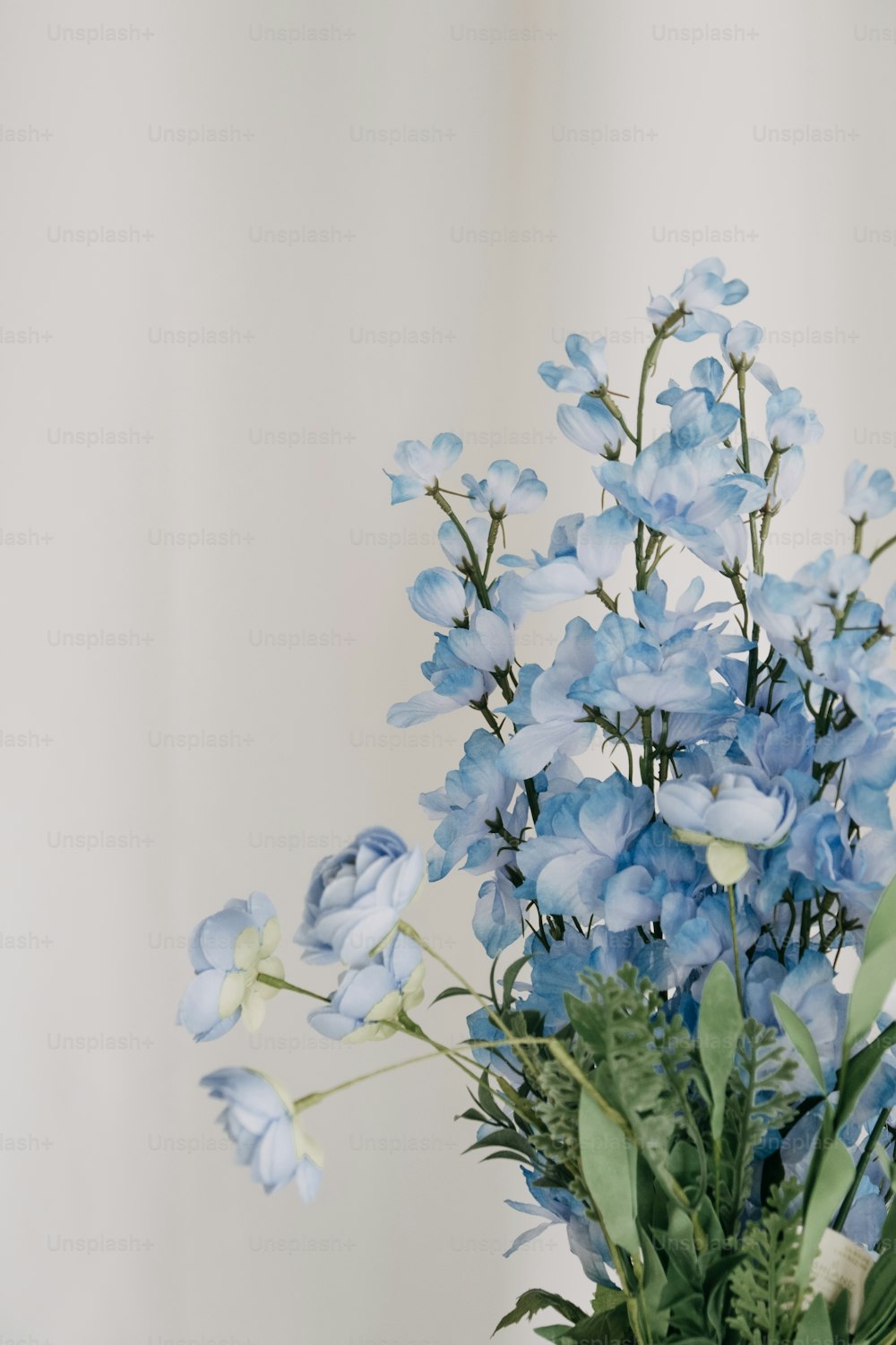 um vaso cheio de flores azuis em cima de uma mesa