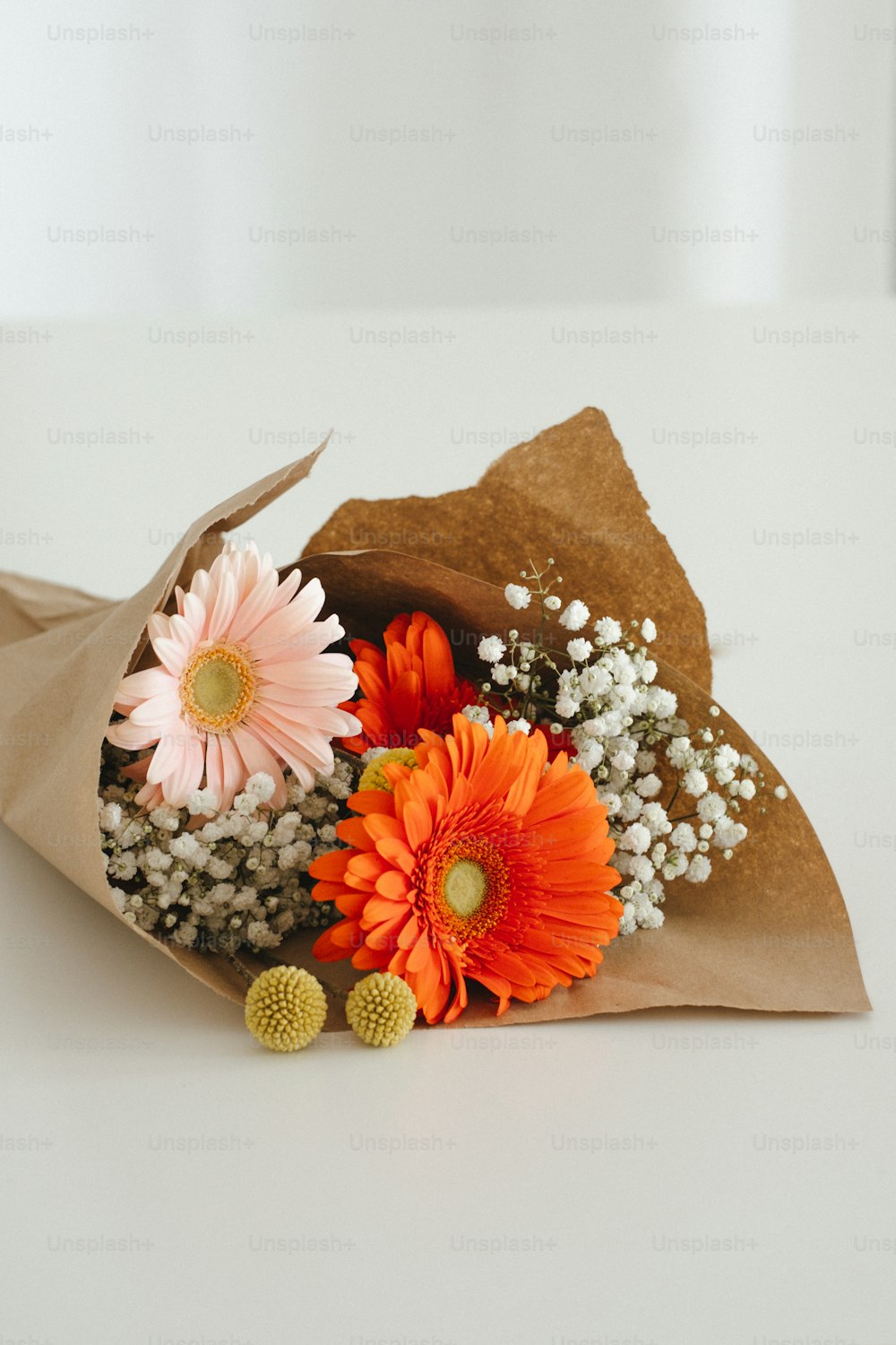 a bouquet of flowers is wrapped in brown paper