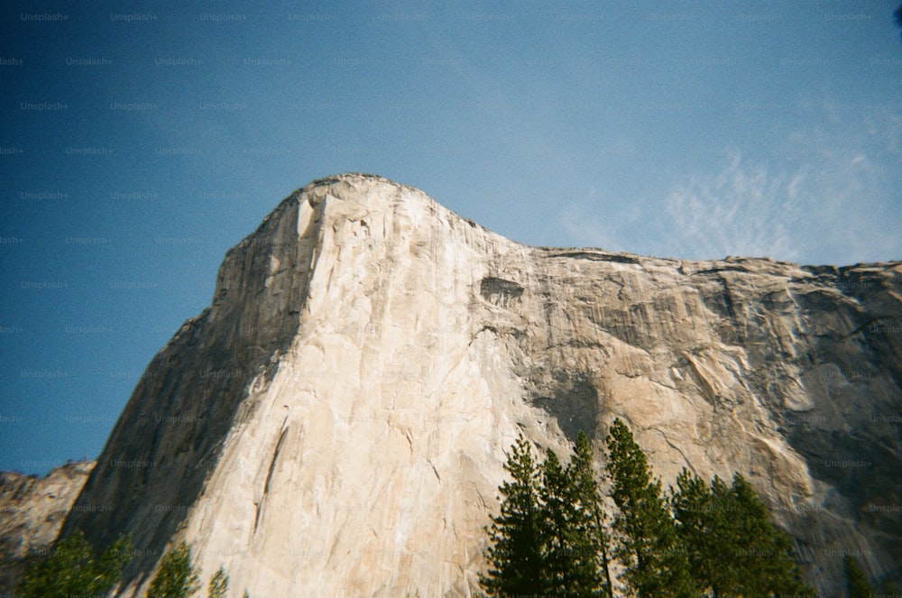 ein hoher Berg mit Bäumen an der Seite