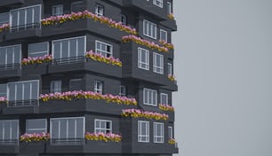 un grand bâtiment avec des fleurs sur les balcons