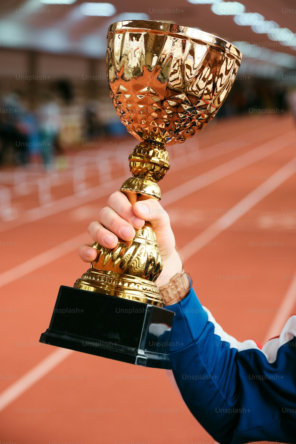a person holding up a trophy on a track