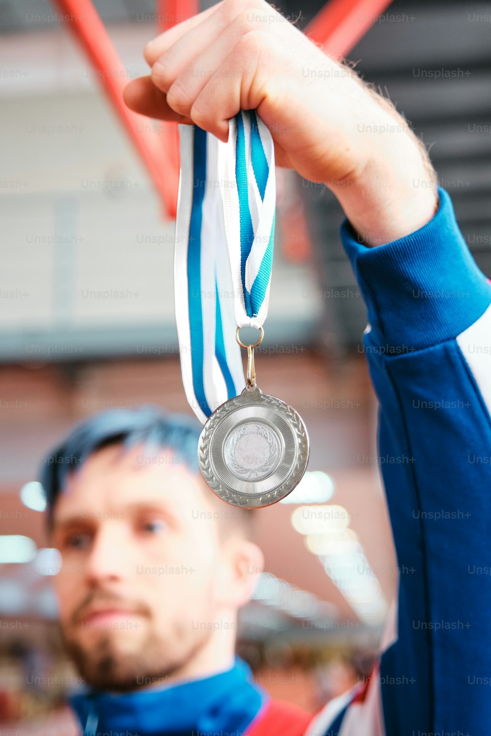 a man holding a silver medal in his right hand