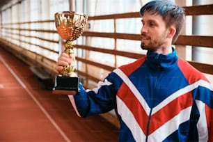 um homem segurando um troféu na mão