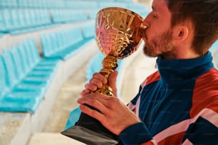 Un homme embrassant un trophée dans un stade