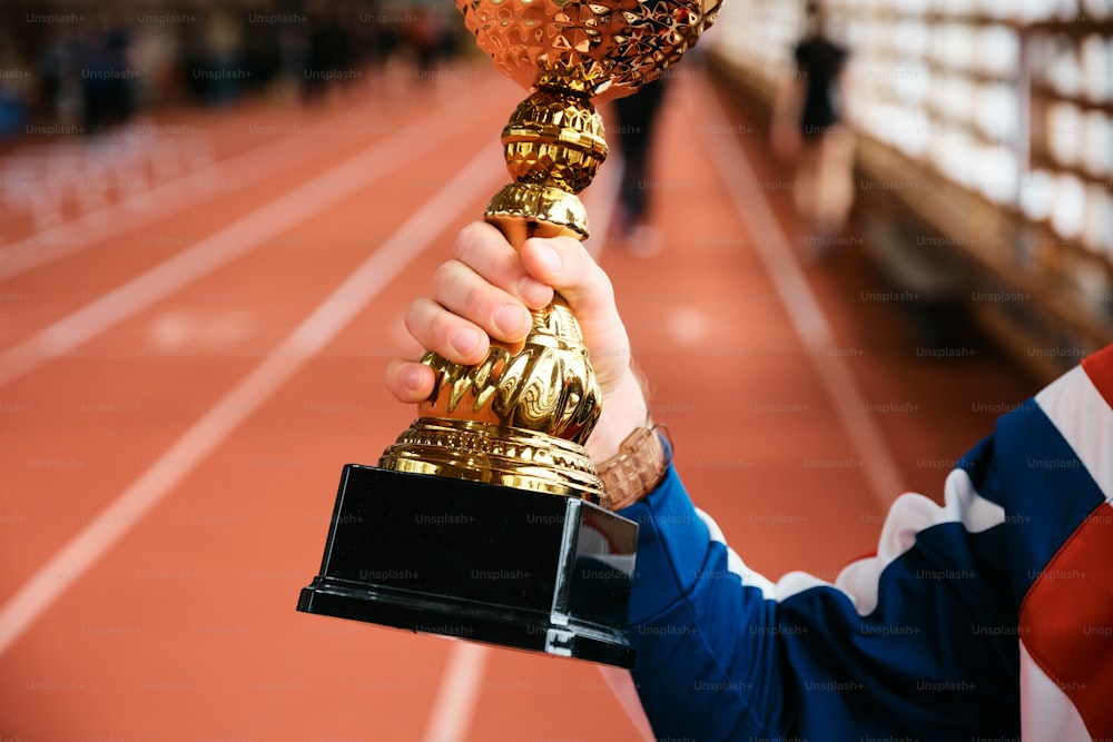 a person holding a trophy on a track