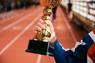 uma pessoa segurando um troféu em uma pista