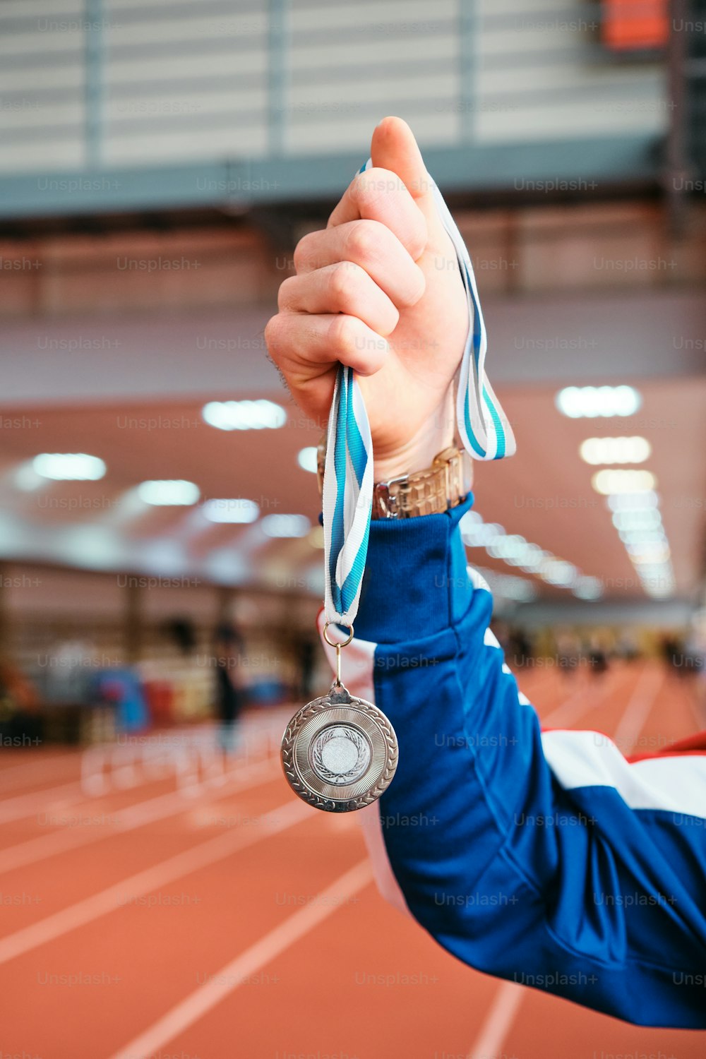 a person holding up a medal on a track