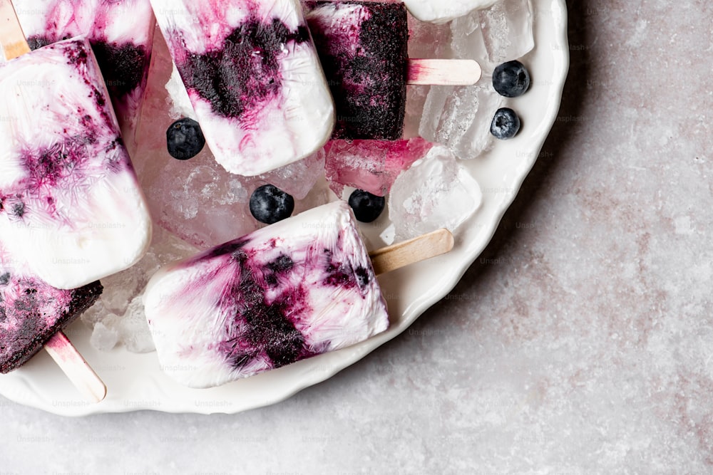 a white plate topped with blueberries and ice cream