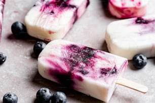 a close up of a popsicle with blueberries on it