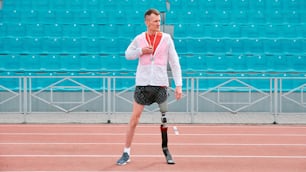 Un hombre con una pierna rota caminando en una cancha de tenis