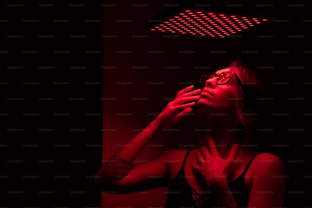 a woman in a dark room with a red light