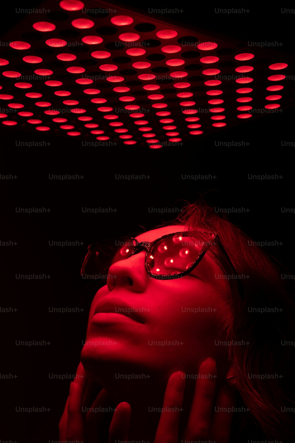 a woman wearing glasses and a red light