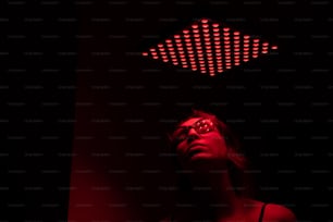 Una mujer en una habitación oscura con una luz roja sobre su cabeza