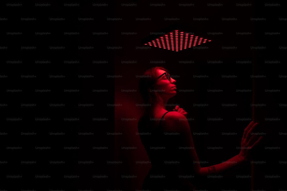 a woman standing in a dark room with a red light on her head