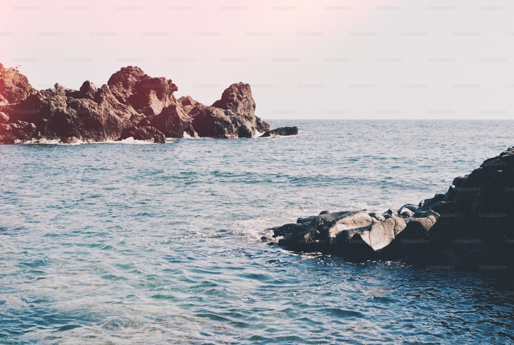 a rock outcropping in the middle of a body of water