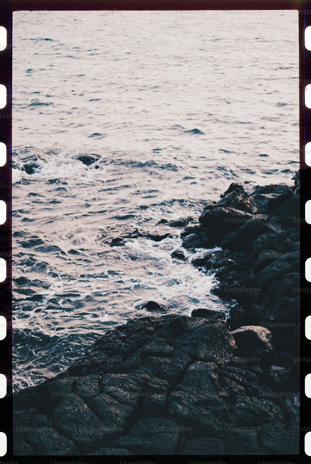 a polaroid photo of the ocean and rocks