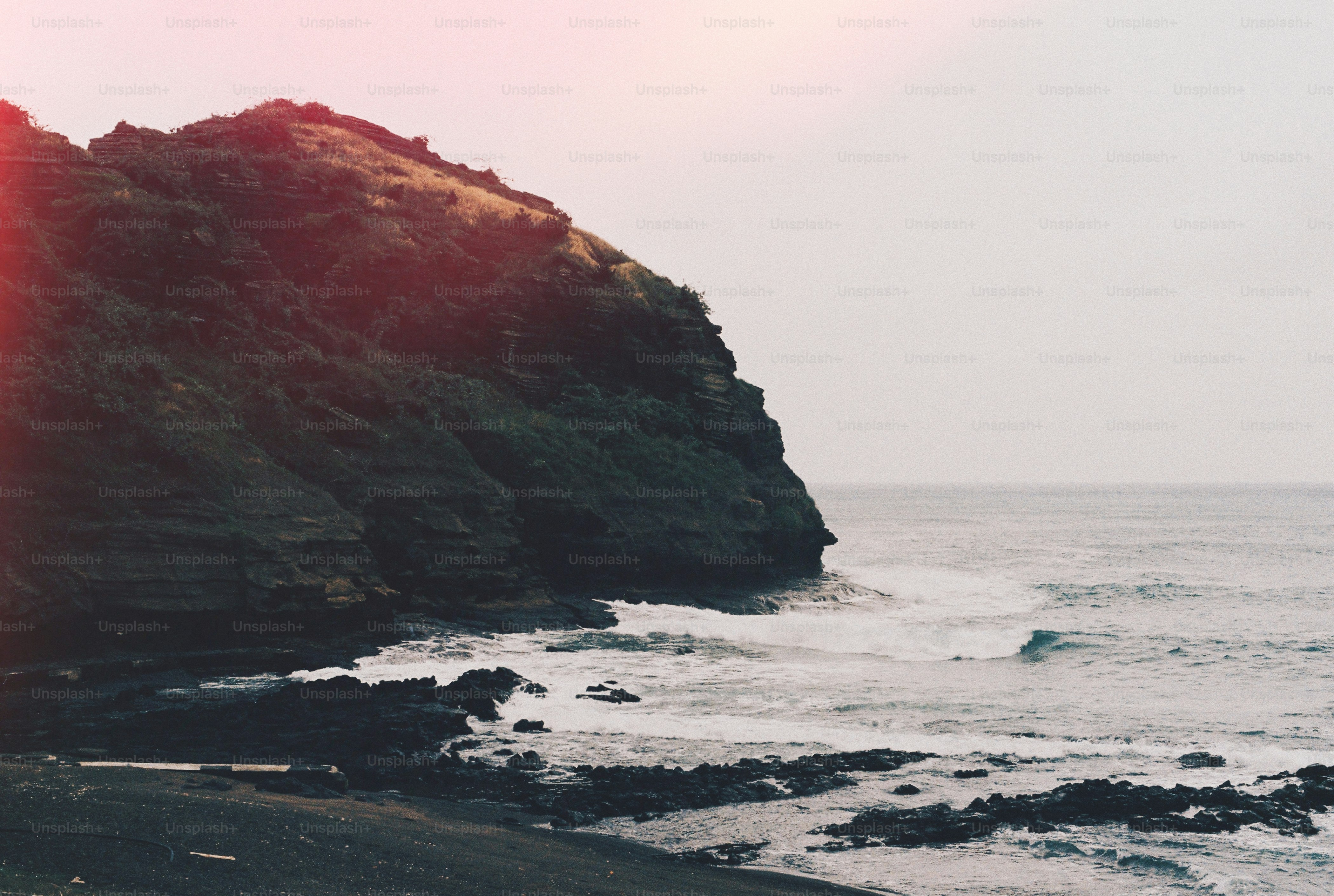 a person riding a surfboard on a rocky beach