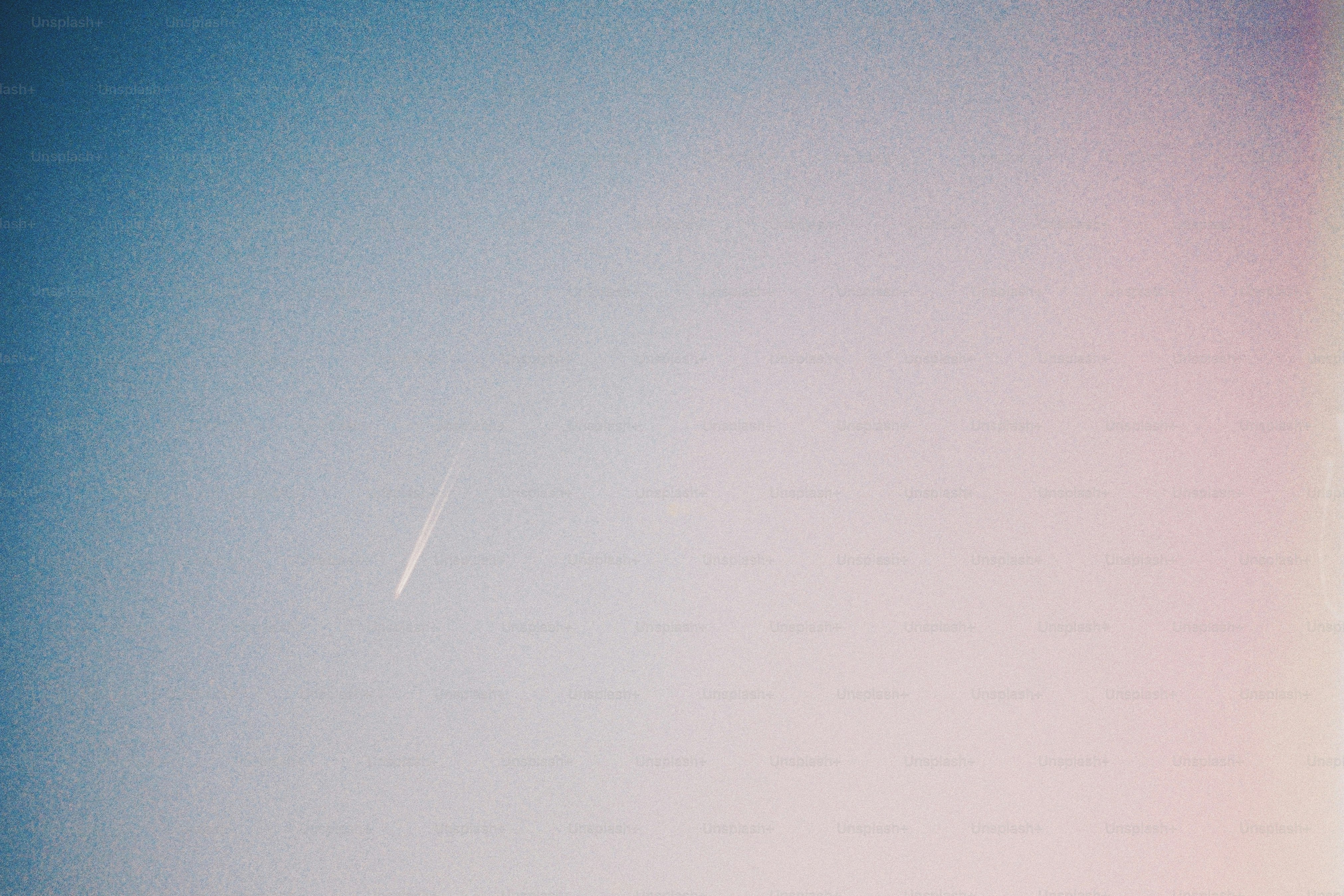 a plane flying in the sky with a contrail