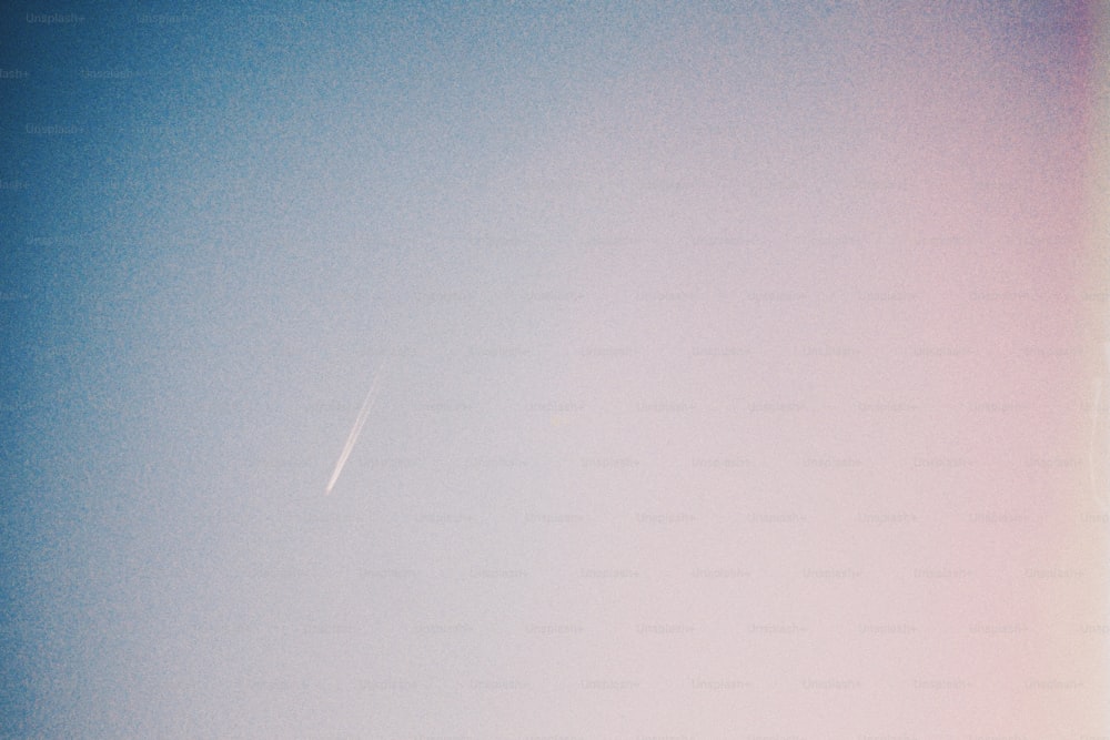 a plane flying in the sky with a contrail