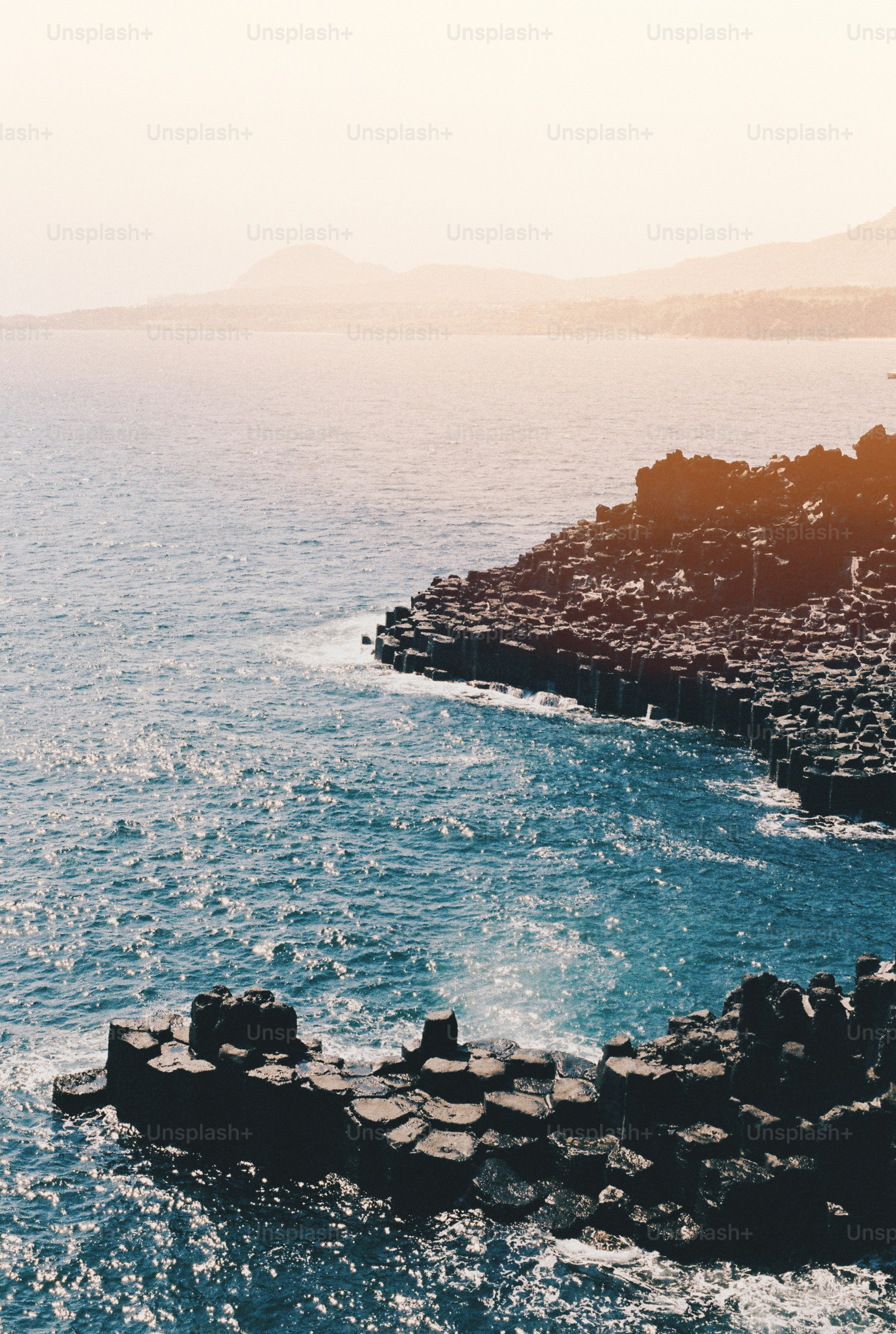 a large body of water next to a rocky shore