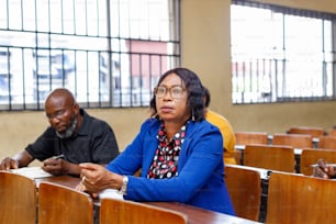 two people sitting at a table in a classroom