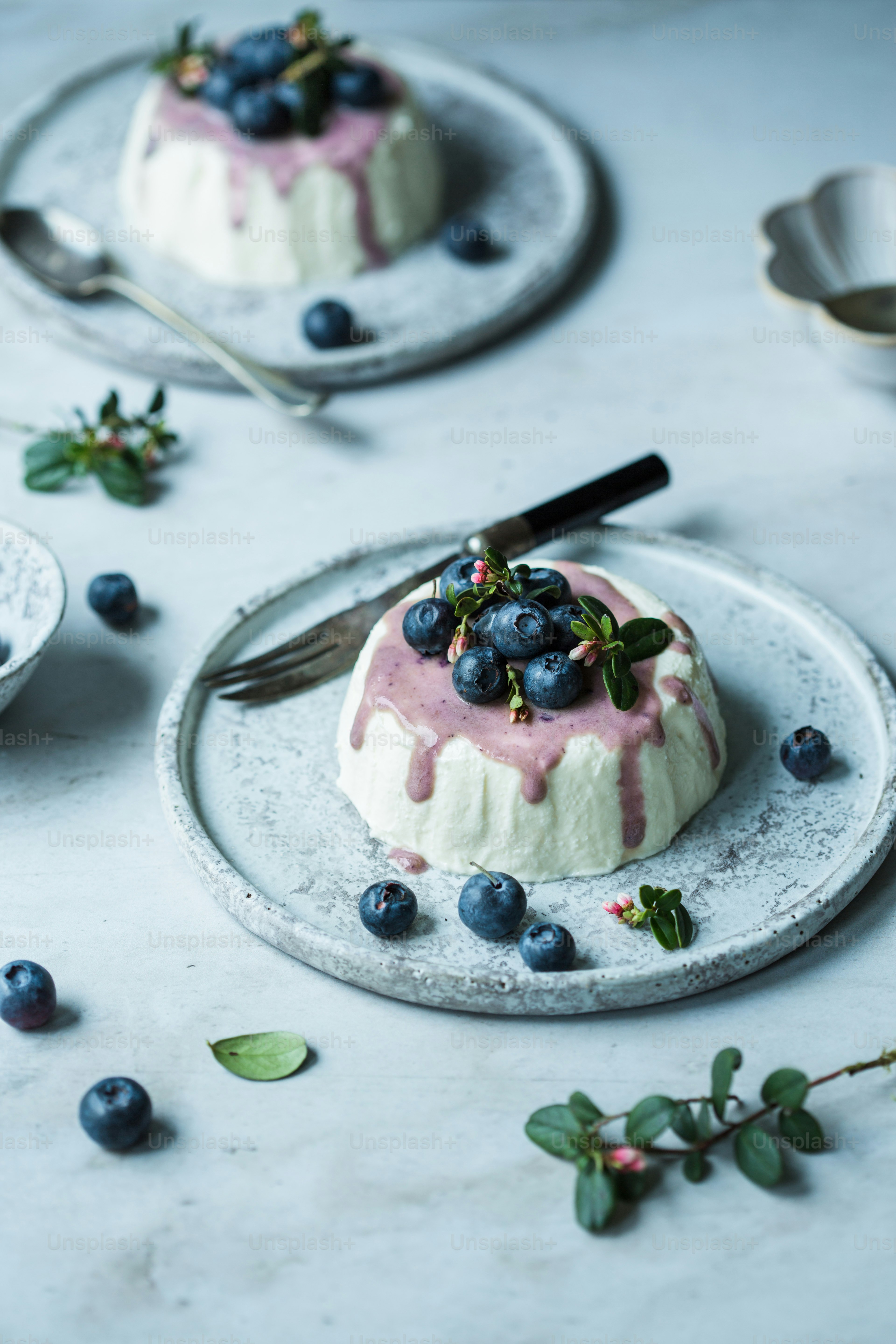 two small cakes with blueberries on top of them