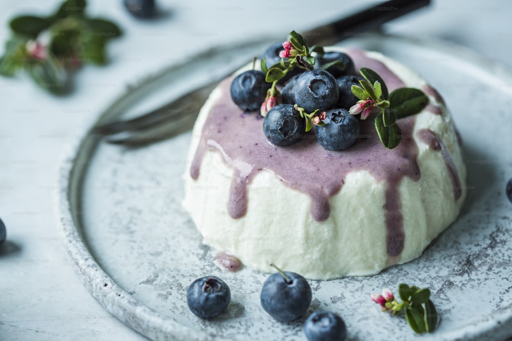 a dessert with blueberries and cream on a plate