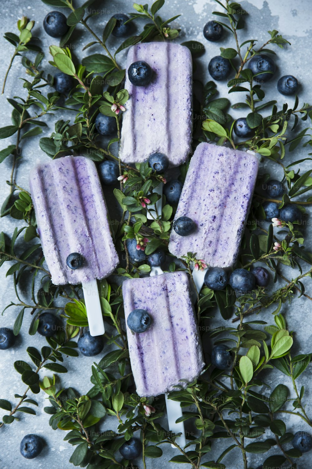 three popsicles with blueberries on top of them