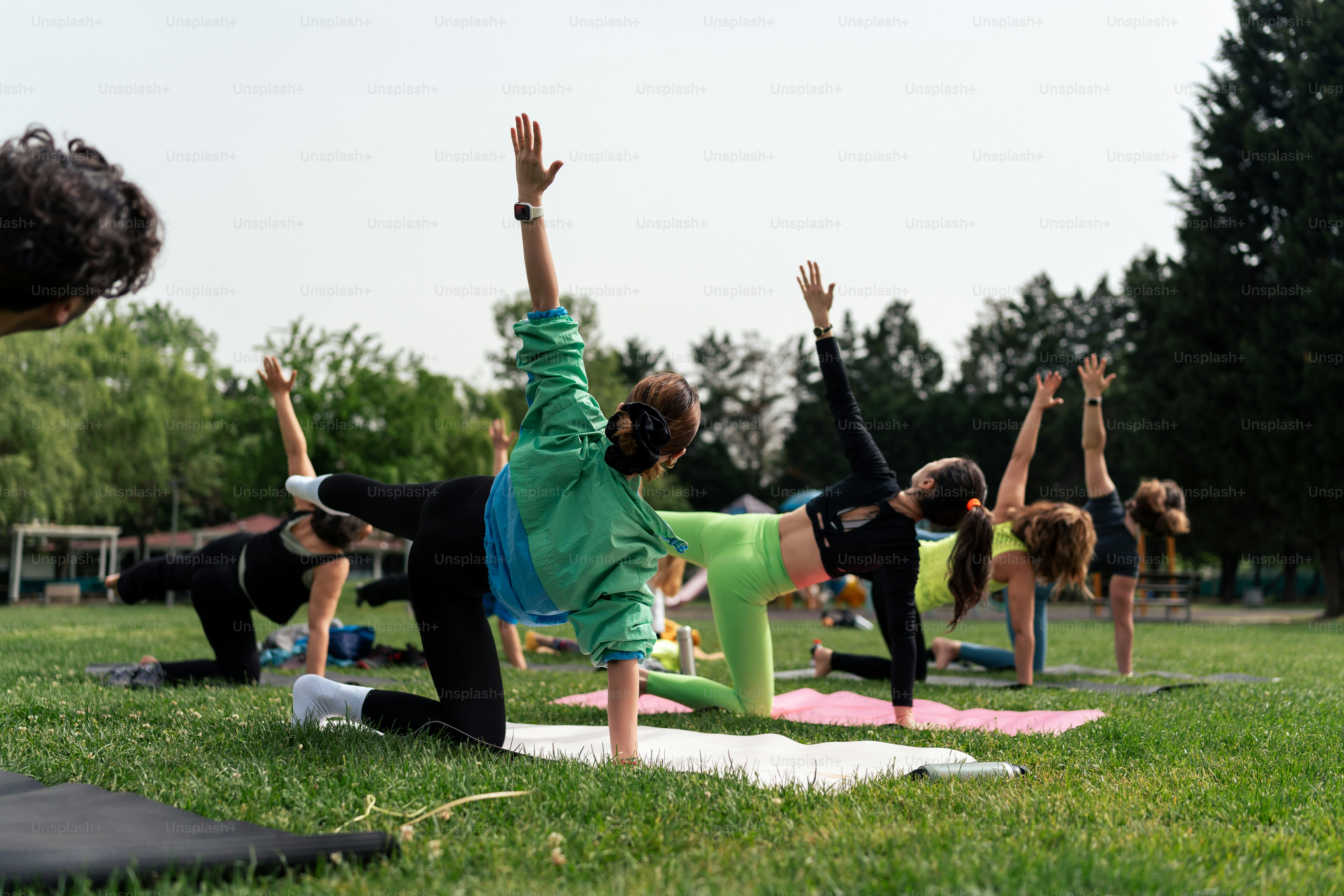 a group of people doing yoga in a park