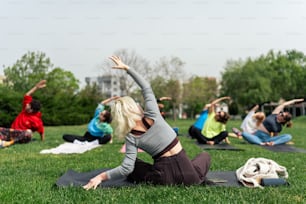 a group of people doing yoga in a park