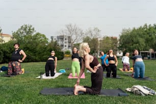 a group of people doing yoga in a park