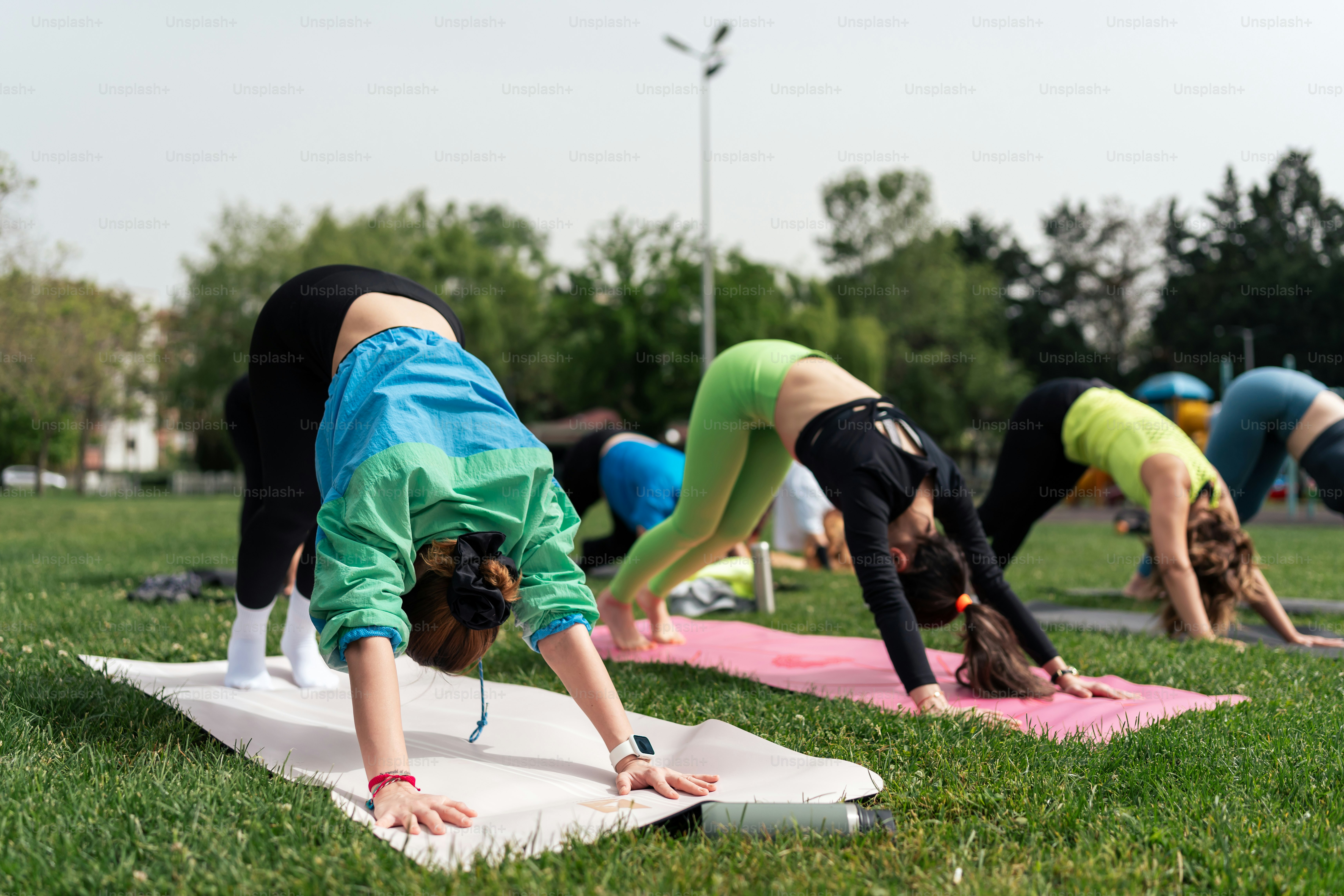 a group of people doing yoga in a park