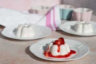 a table topped with white plates filled with dessert