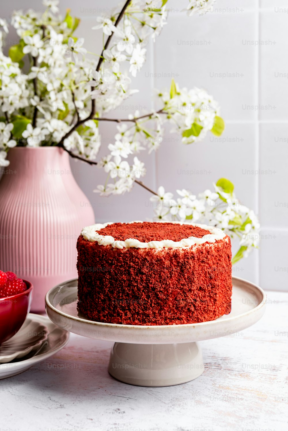 um bolo vermelho sentado em cima de um prato branco