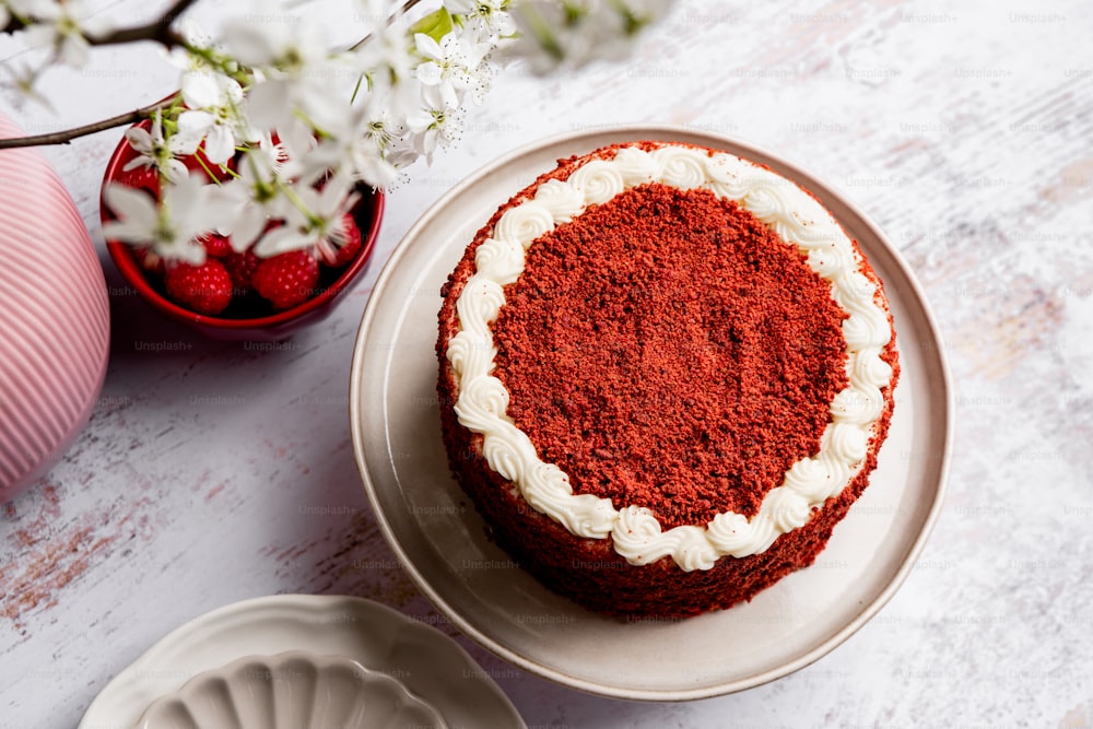 皿に白いフロスティングを施した赤いベルベットのケーキ