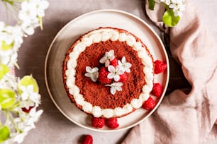 a cake on a plate with raspberries and flowers