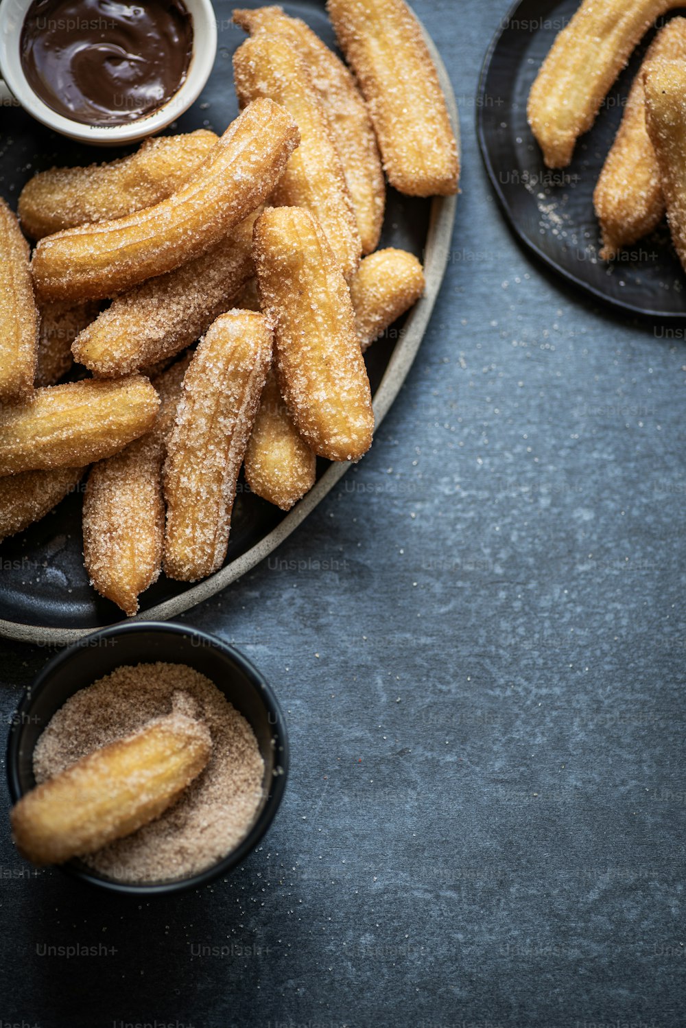 a plate of churros and dipping sauce on a table