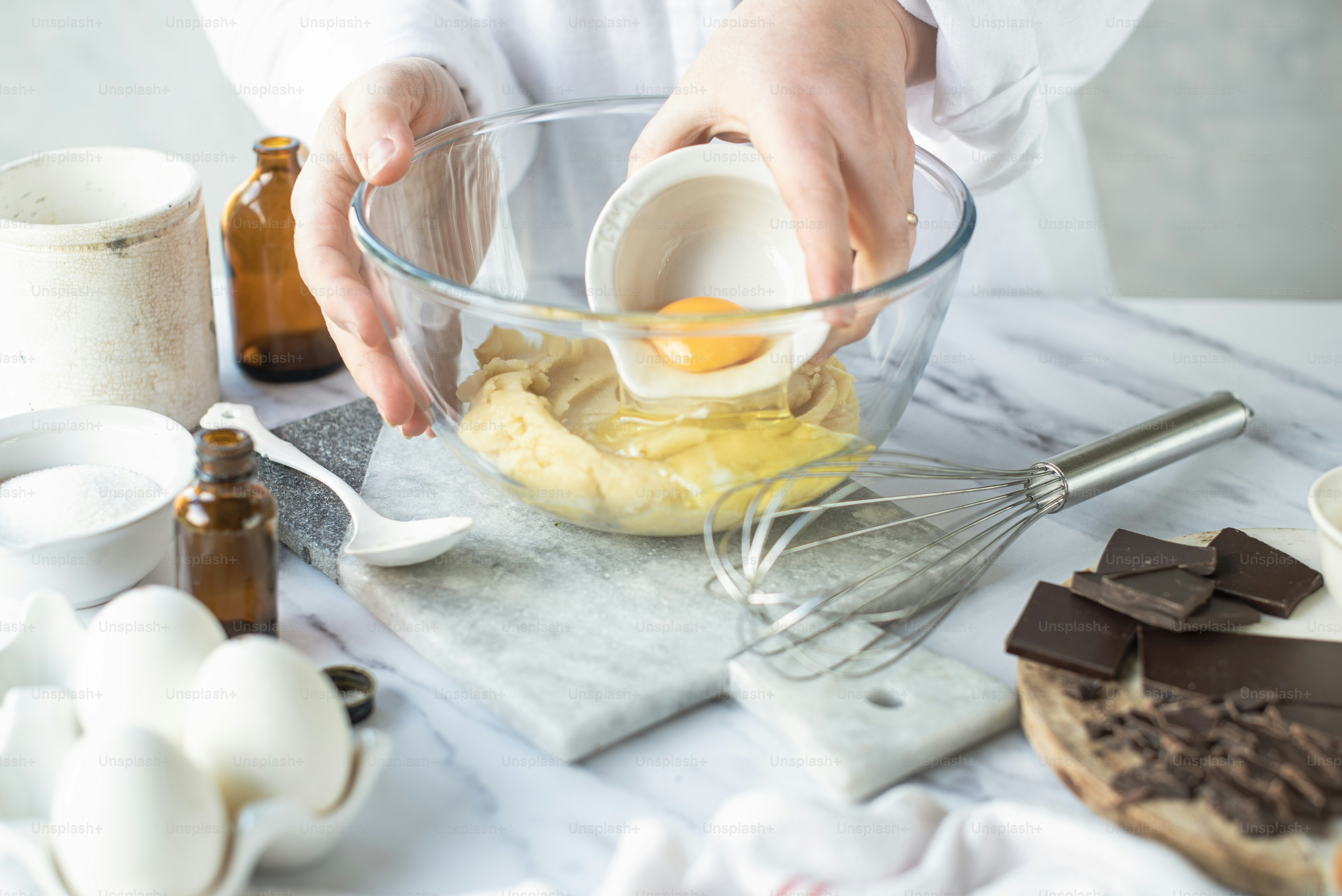 a person mixing ingredients in a glass bowl