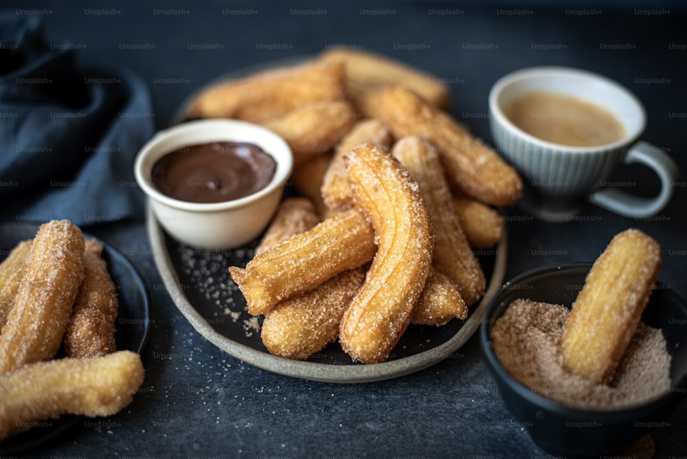 a plate of churros with dipping sauce on the side
