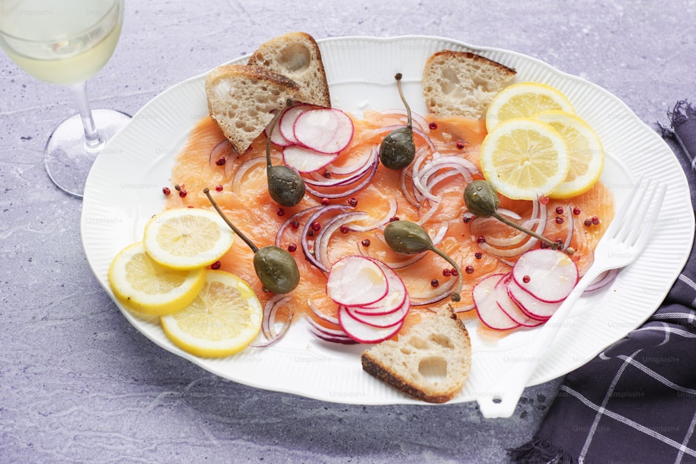 a white plate topped with sliced up fish and veggies