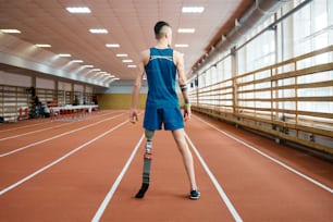 a man standing on a track with a tennis racket in his hand