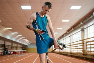 a man in a blue tank top holding a skateboard