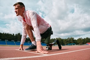 a man kneeling down on top of a tennis court