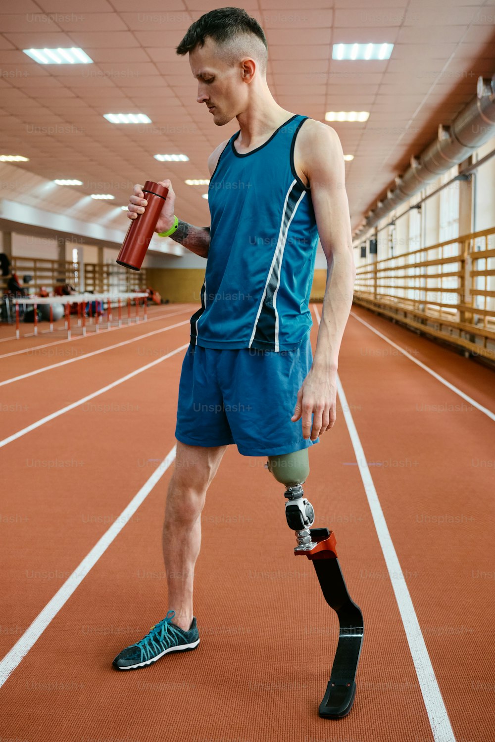 un uomo con una gamba rotta che tiene in mano una bottiglia d'acqua
