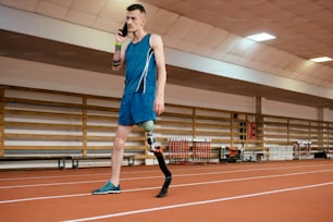 a man with a broken leg walking on a track